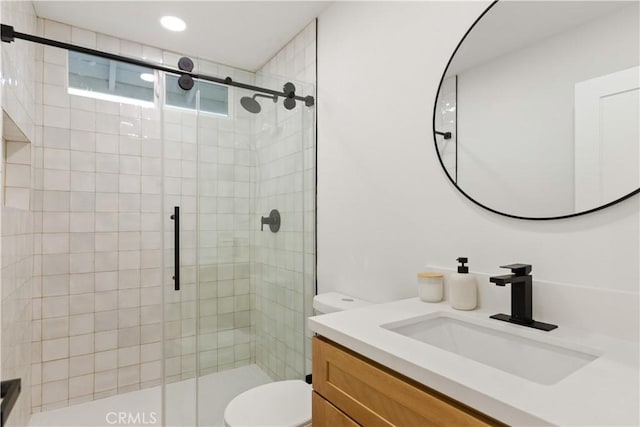 full bathroom with a stall shower, vanity, and toilet