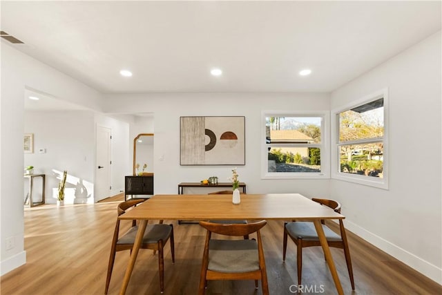 dining space featuring visible vents, baseboards, wood finished floors, and recessed lighting