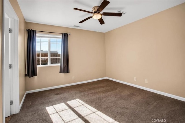 carpeted spare room featuring visible vents, ceiling fan, and baseboards