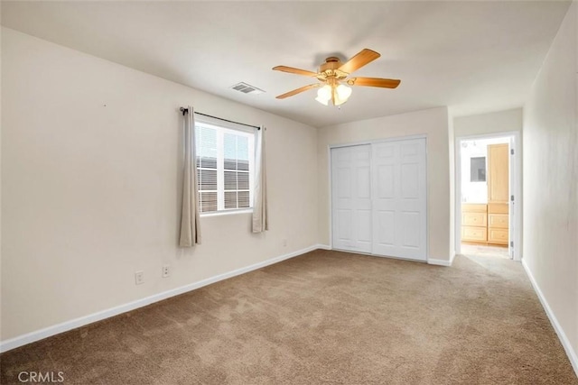 unfurnished bedroom with baseboards, visible vents, a ceiling fan, carpet flooring, and a closet