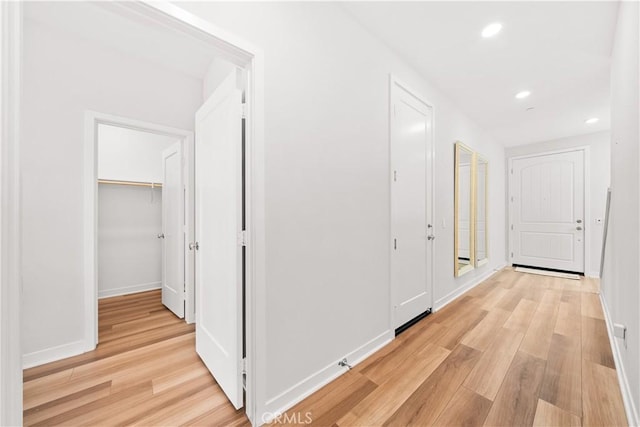 hall featuring light wood-style floors, recessed lighting, and baseboards