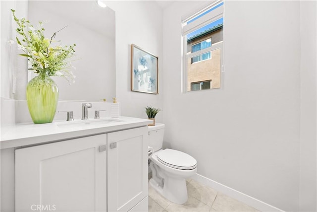 bathroom with baseboards, vanity, toilet, and tile patterned floors