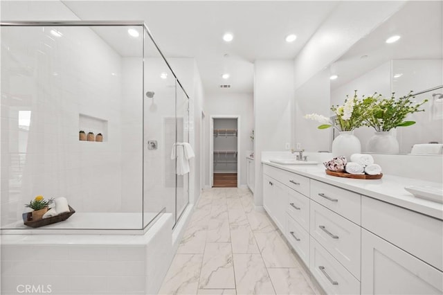 bathroom featuring recessed lighting, vanity, marble finish floor, a spacious closet, and a stall shower