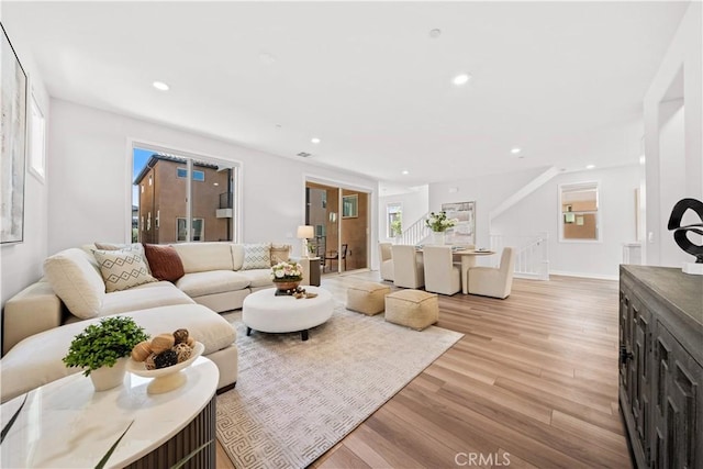 living area with baseboards, light wood-style flooring, and recessed lighting