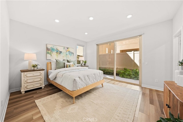 bedroom with baseboards, wood finished floors, access to exterior, and recessed lighting