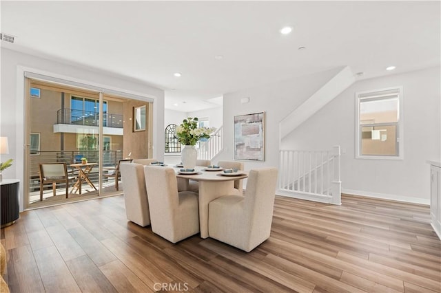 dining space with light wood finished floors and recessed lighting