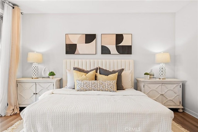 bedroom with baseboards and wood finished floors