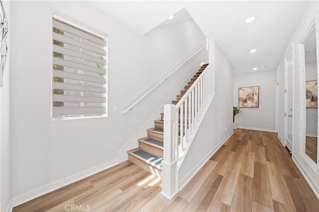 stairway with recessed lighting, wood finished floors, and baseboards