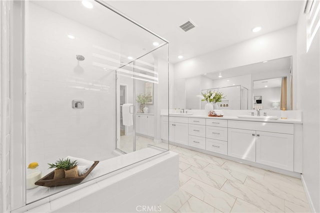 full bathroom featuring marble finish floor, double vanity, visible vents, a sink, and a tile shower