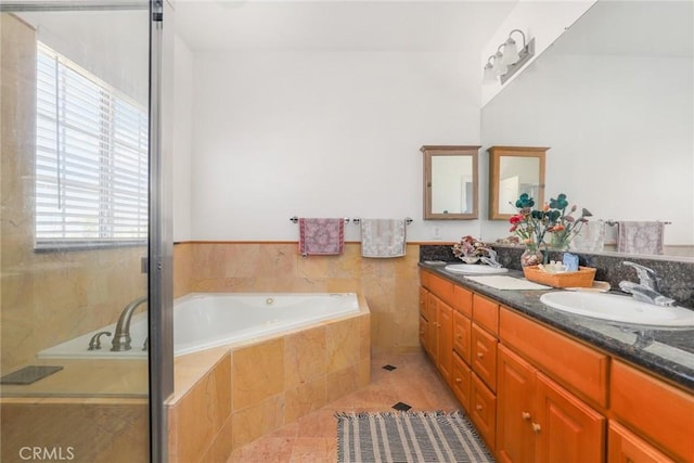 full bathroom with a garden tub, double vanity, a sink, and tile patterned floors