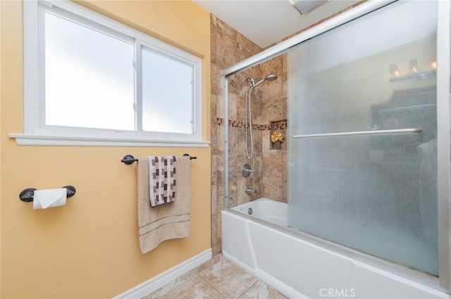 bathroom with tile patterned flooring, baseboards, and combined bath / shower with glass door