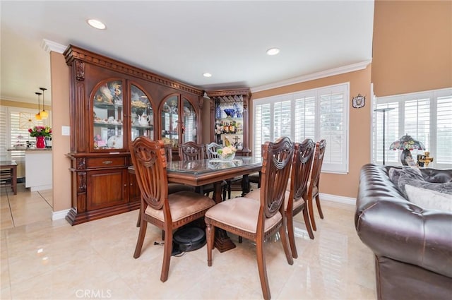 dining room featuring a healthy amount of sunlight, crown molding, and baseboards