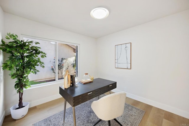 home office featuring baseboards and wood finished floors