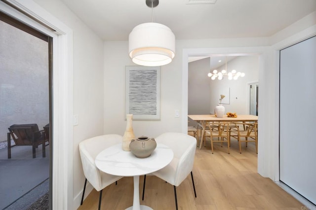 dining area with light wood-type flooring and visible vents