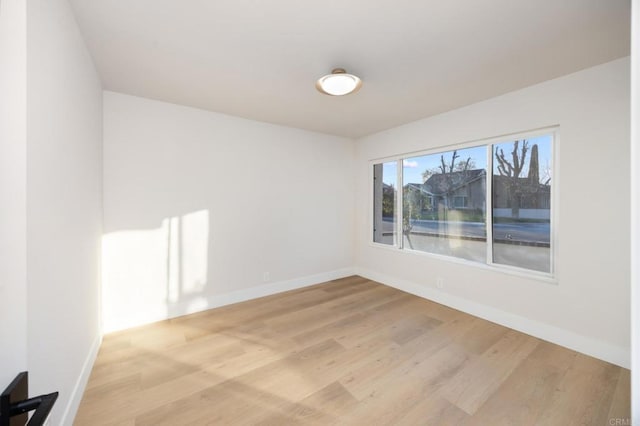 spare room with light wood-style flooring and baseboards