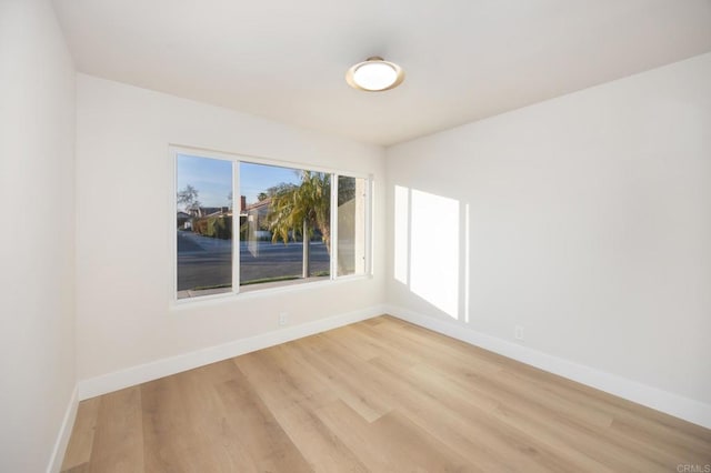 unfurnished room featuring light wood-style flooring and baseboards