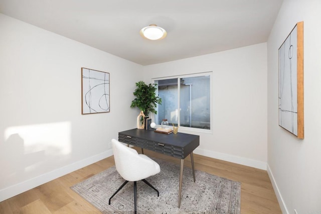 office area featuring light wood-style floors and baseboards