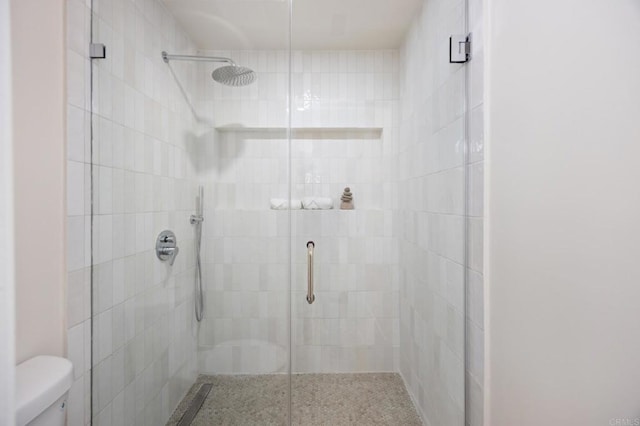 bathroom with a shower stall and toilet