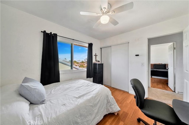 bedroom featuring ceiling fan, a closet, and wood finished floors