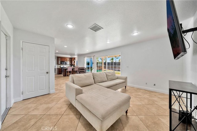 living area with light tile patterned floors, baseboards, visible vents, and recessed lighting