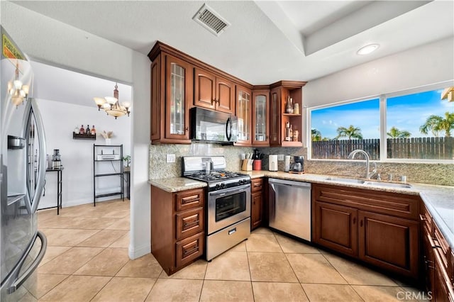 kitchen featuring visible vents, decorative backsplash, appliances with stainless steel finishes, a sink, and light tile patterned flooring