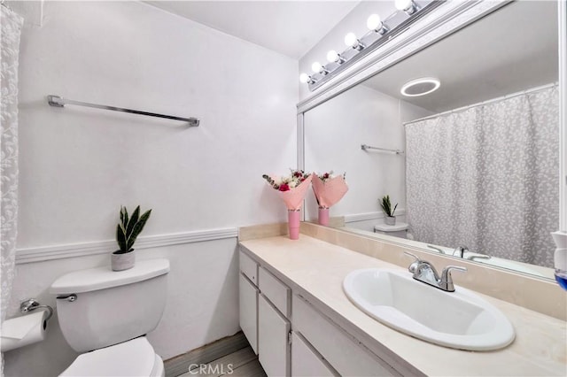 full bathroom with wood finished floors, vanity, toilet, and curtained shower