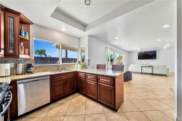 kitchen with appliances with stainless steel finishes, light tile patterned flooring, a sink, and tasteful backsplash