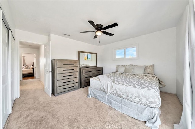 bedroom featuring visible vents, a ceiling fan, and light colored carpet