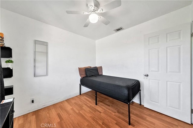 sitting room featuring a ceiling fan, visible vents, light wood-style flooring, and baseboards