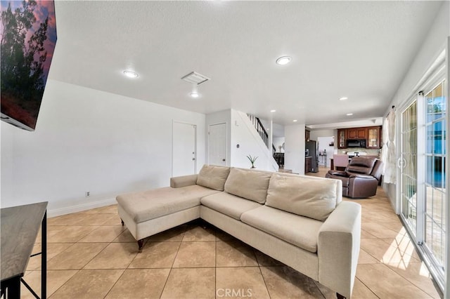 living area featuring baseboards, visible vents, stairs, light tile patterned flooring, and recessed lighting