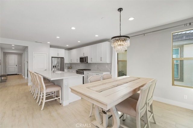 dining space featuring recessed lighting, visible vents, light wood-style flooring, an inviting chandelier, and baseboards