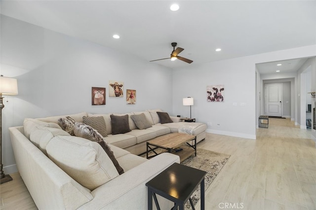 living room featuring baseboards, ceiling fan, recessed lighting, and light wood-style floors