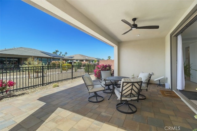 view of patio / terrace with outdoor dining area, fence, and a ceiling fan