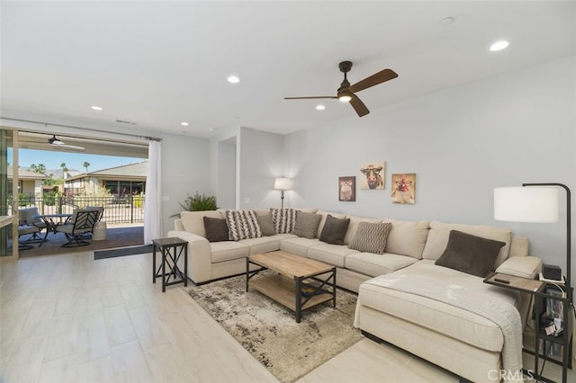 living room with light wood-type flooring, ceiling fan, and recessed lighting