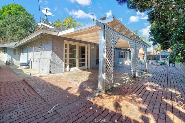 back of property featuring french doors, fence, a patio, and stucco siding