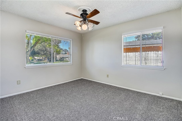 carpeted empty room featuring ceiling fan, baseboards, and a textured ceiling