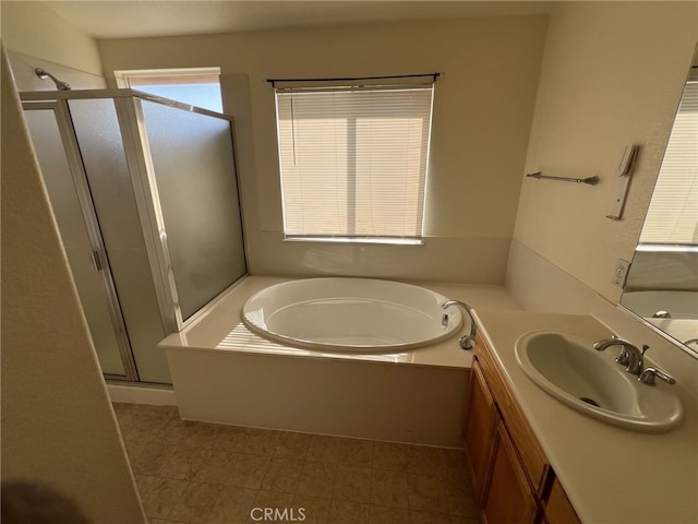 bathroom with a stall shower, a bath, and vanity