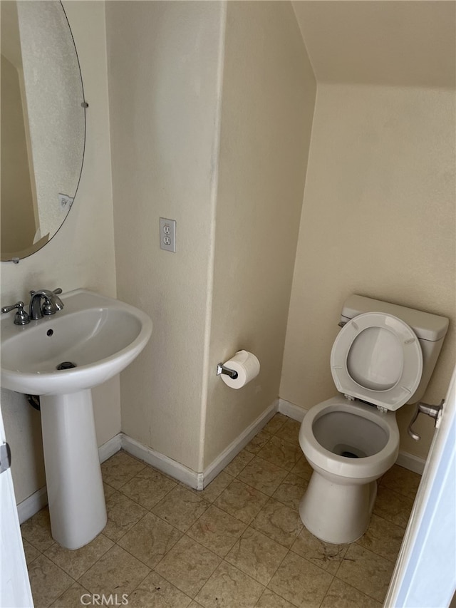 bathroom featuring toilet and baseboards