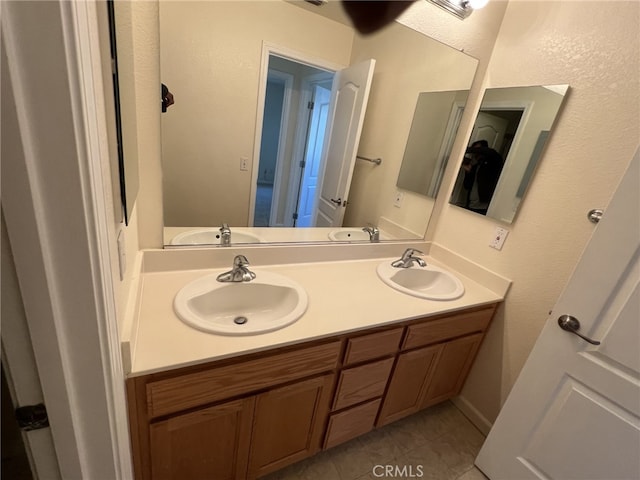 bathroom with double vanity, a sink, and tile patterned floors