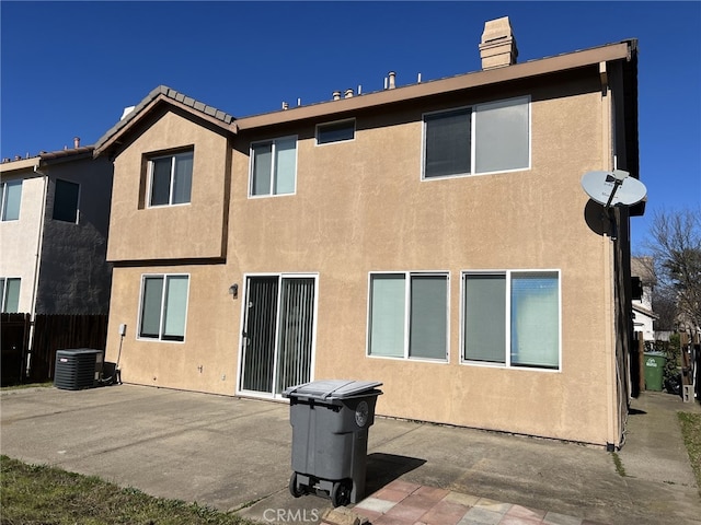 back of property with a patio area, fence, a chimney, and stucco siding