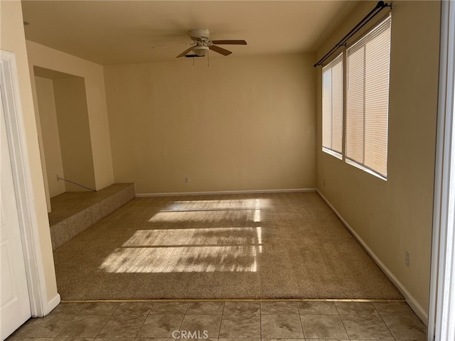 unfurnished room featuring ceiling fan, carpet, and baseboards