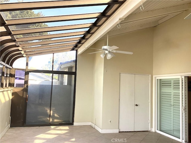 unfurnished sunroom featuring vaulted ceiling with beams