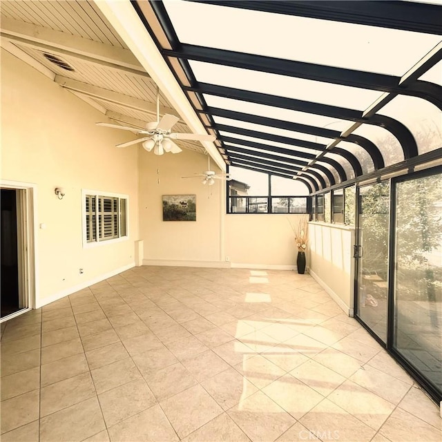 unfurnished sunroom with a ceiling fan and lofted ceiling with beams