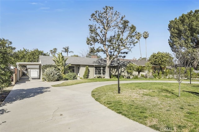 view of front facade with concrete driveway, a carport, and a front lawn