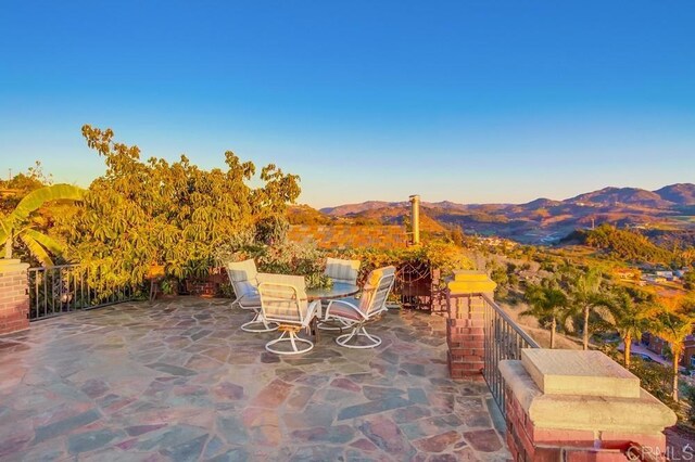 view of patio / terrace with outdoor dining space and a mountain view