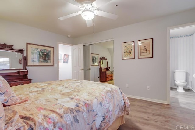 bedroom with baseboards, a ceiling fan, connected bathroom, wood finished floors, and a closet