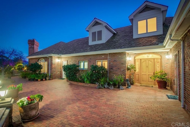 view of front facade featuring a patio area and brick siding