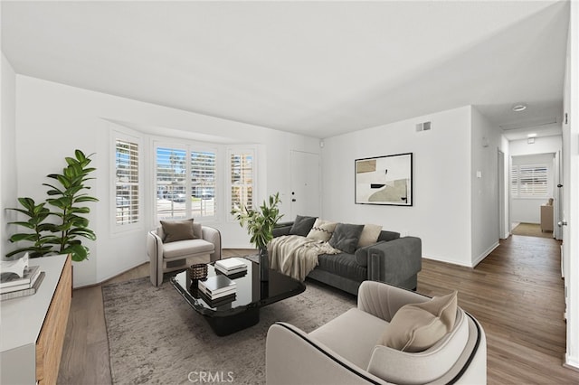 living room featuring visible vents and wood finished floors