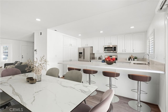 kitchen featuring a peninsula, appliances with stainless steel finishes, and a kitchen bar