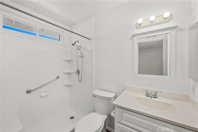 bathroom featuring toilet, walk in shower, and vanity